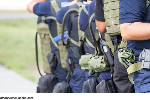 Line of law enforcement personnel wearing gear on a training mission