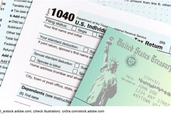 A paper check from the Department of the Treasury on top of a paper copy of the individual tax return Form 1040.