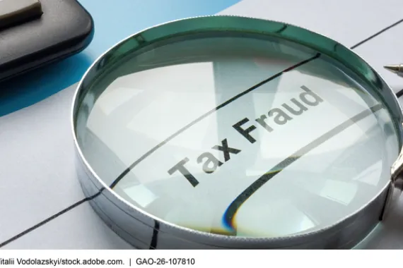 A magnifying glass over the words tax fraud
