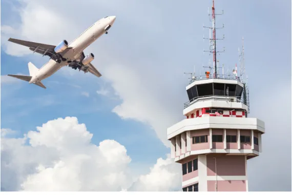 Air traffic control tower with airplane flying nearby