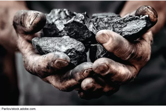Pile of coal in man's dirty hands