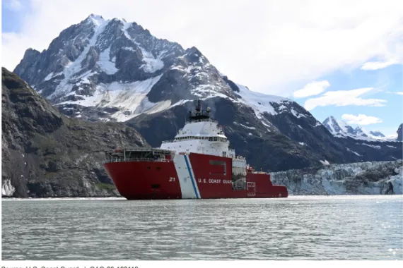 Coast Guard ship at sea with snow-topped mountain behind it.