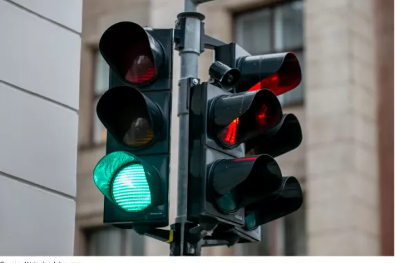 A traffic light at an intersection, green in one direction and red in the other.