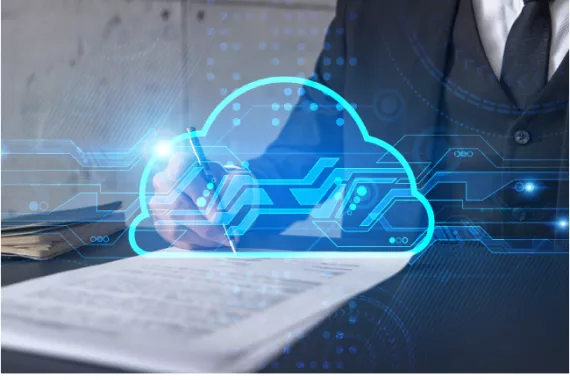 A person at a desk wearing a business suit is signing a contract. Above the contract is an image of an electronic cloud.