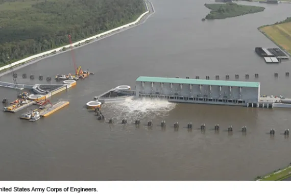 Aerial view of a levee spanning a waterway, with an opening in the center.
