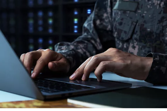 Person in military uniform on a laptop