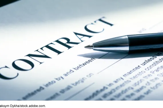 A pen on a paper that says contract.