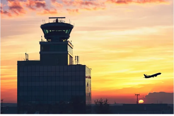 A plane taking off behind an air traffic control tower