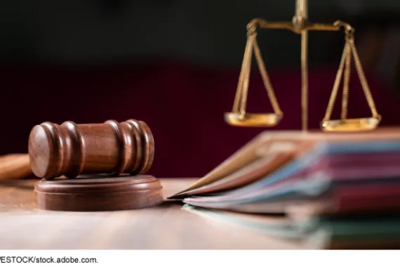 Gavel and scales of justice on a wood table with file folders