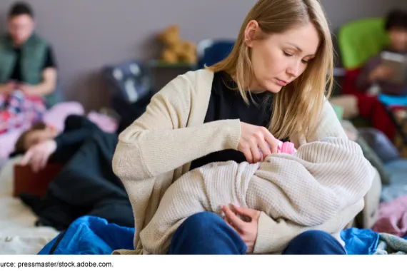 A mother holding and feeding her baby with a bottle.