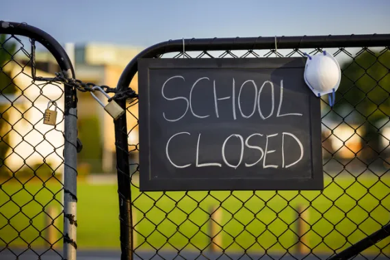 A sign on a school gate that says School Closed.