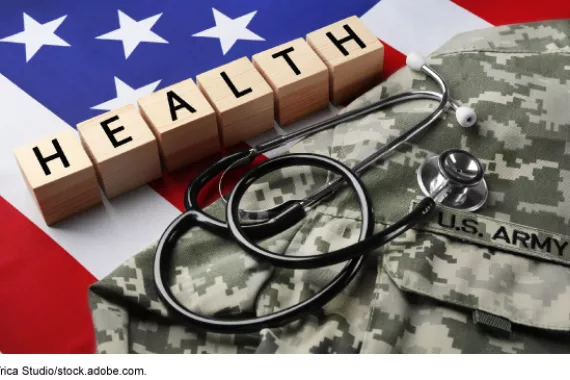 A U.S. military uniform and medical stethoscope laying on top of an American flag with wood blocks that spell out HEALTH. 