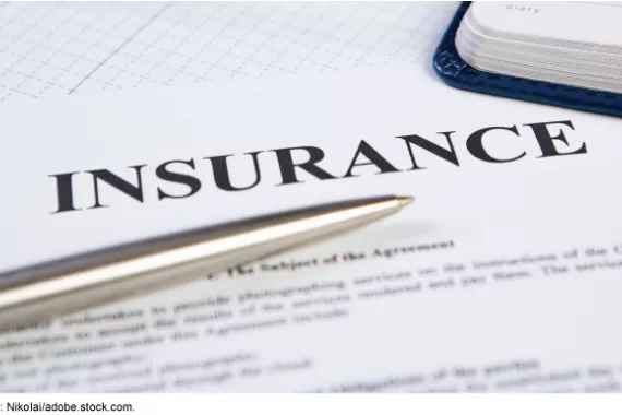 A piece of paper with the word INSURANCE at the top in big bold letters, with a silver pen and the corner of a notebook on top of the paper.