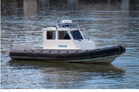 A small boat that says police on the side in the water.