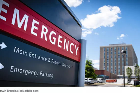 An emergency room sign leading to a parking lot at a hospital