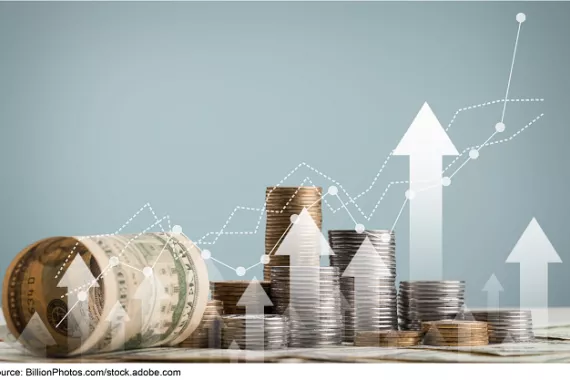 Piles of coins and American currency with stylized white arrows and dotted lines superimposed on top pointing upwards.