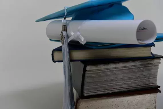 Photo Showing Mortarboard, Diploma, and Books