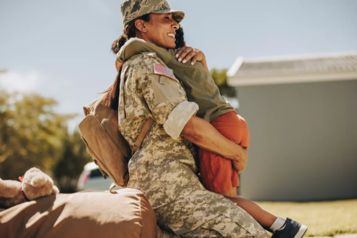 Military woman hugging child