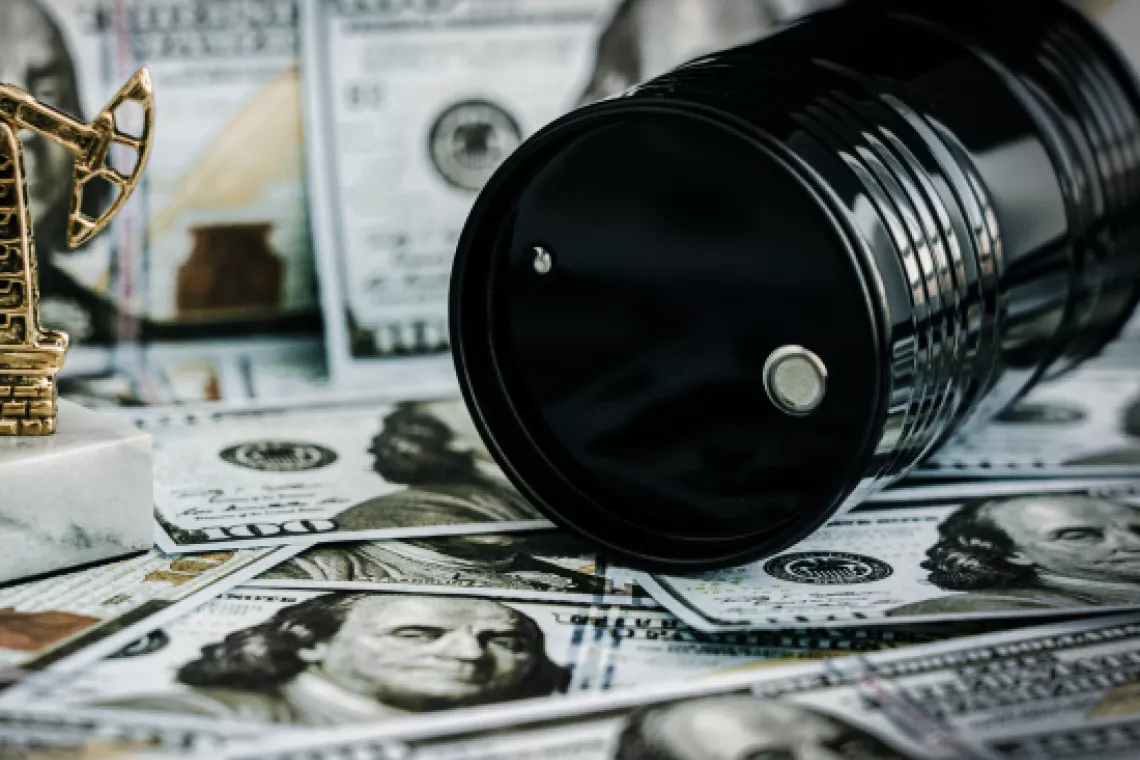 Graphic of an oil barrel on top of money