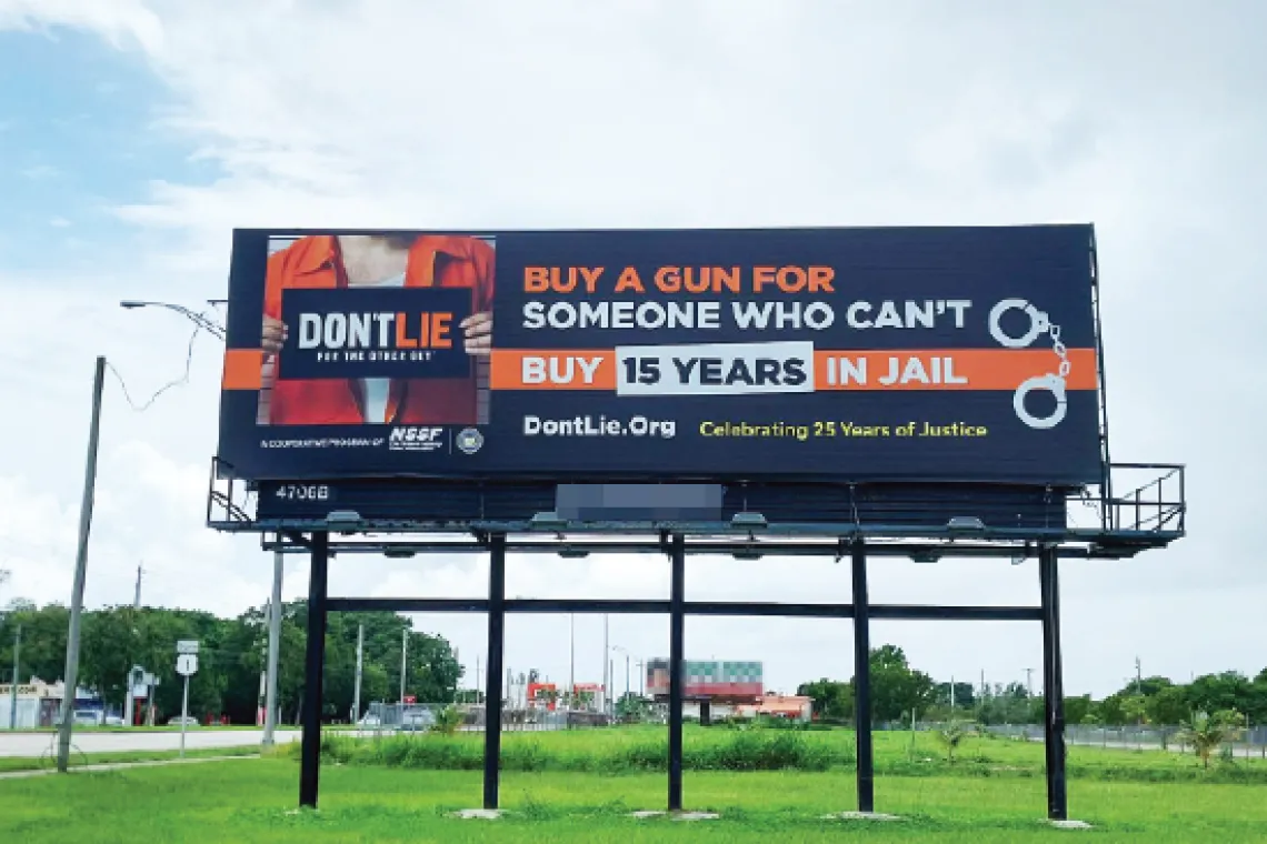 A photo of a billboard instructing viewers not to buy a gun for somebody who can't, or face up to 15 years in prison.