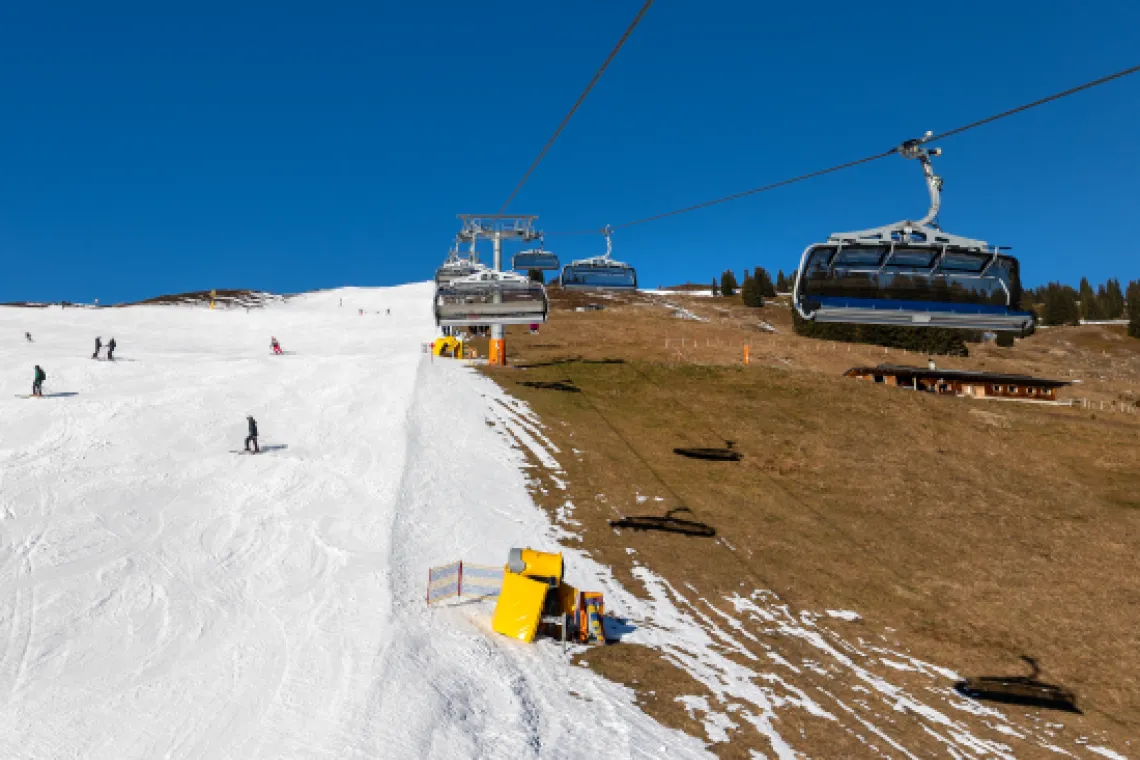 Snow cannons by a ski lift.