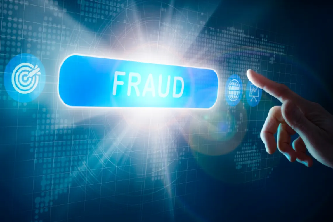 A hand reaching toward a button that says 'Fraud'.